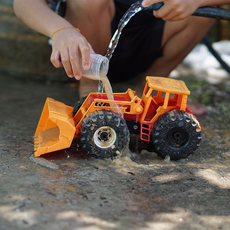 kids washing toy truck in driveway