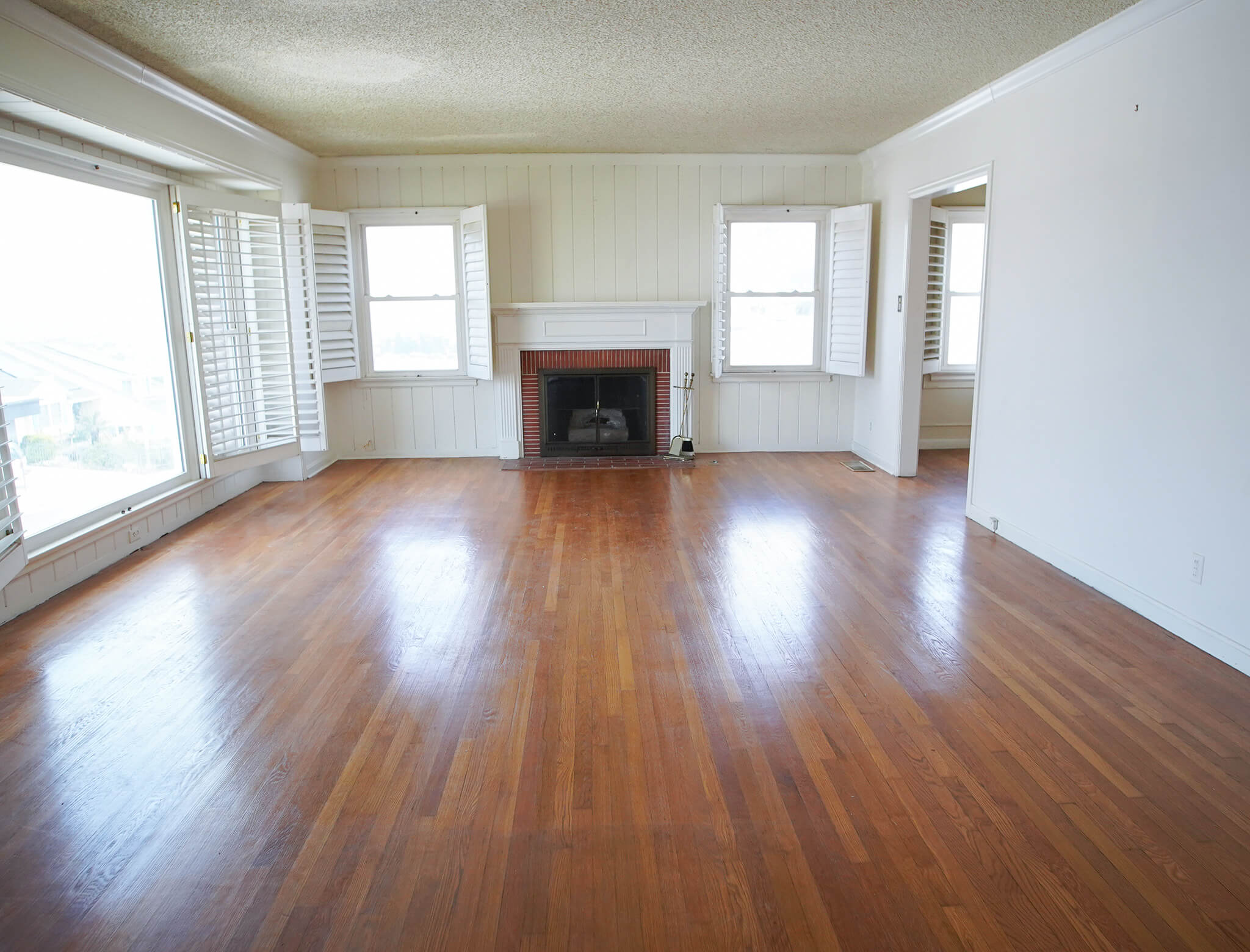outdated living room with orange wood floors