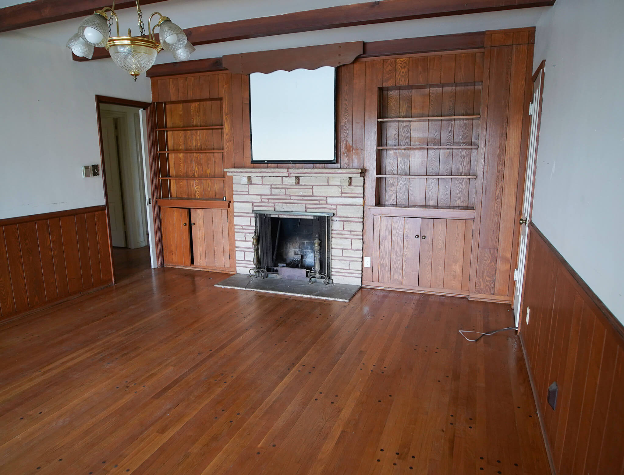 old living room with a projector screen and dingy fireplace