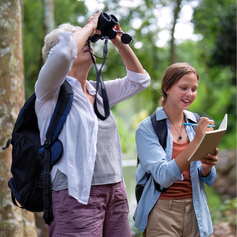 older woman and young girl bird watching