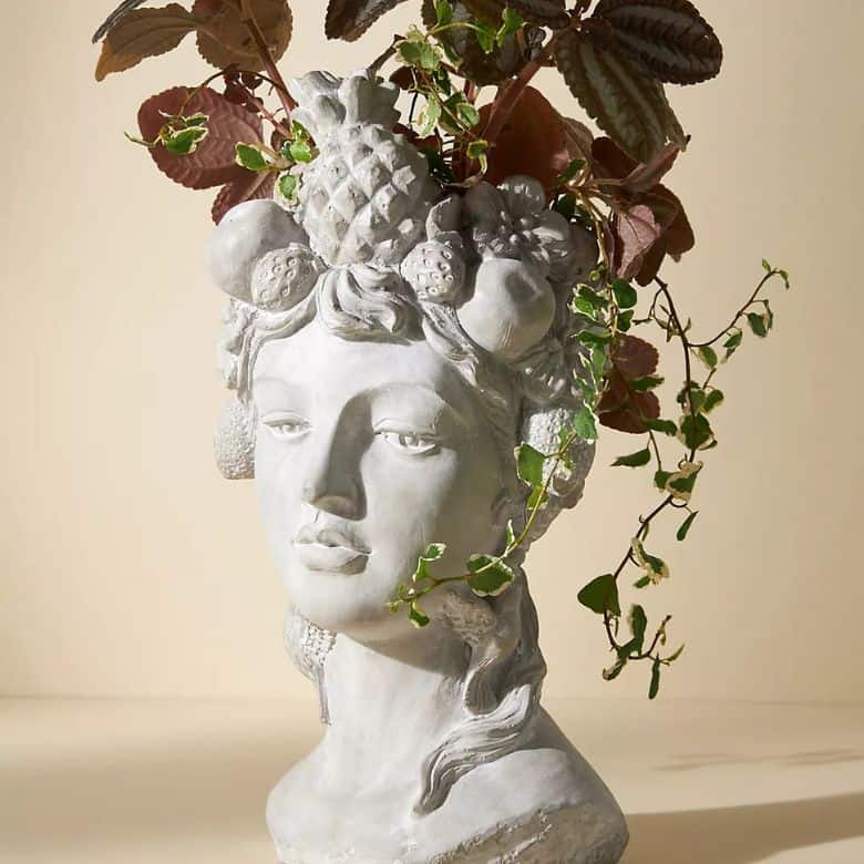 multicolored plant inside grecian bust planter pot