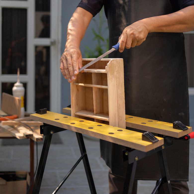 man carving a wooden decorative shelf