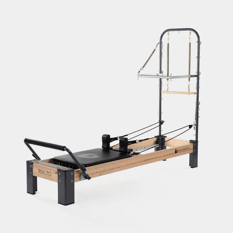 balanced body reformer machine with tower and mat for at-home pilates workouts