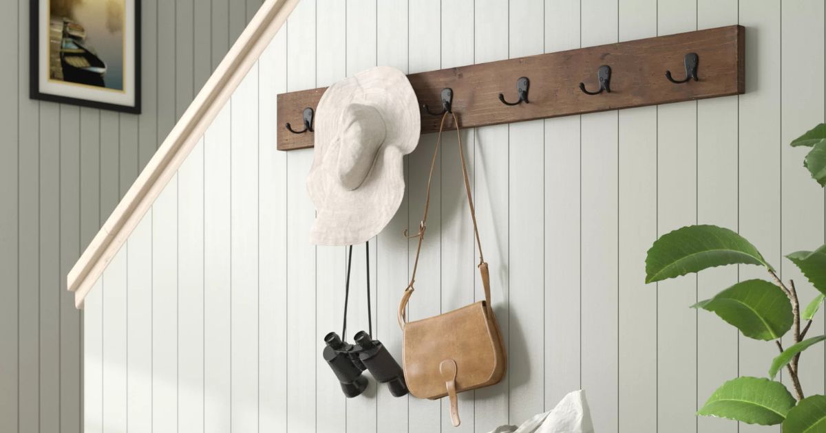 coat racks with hat and purses hung next to a staircase