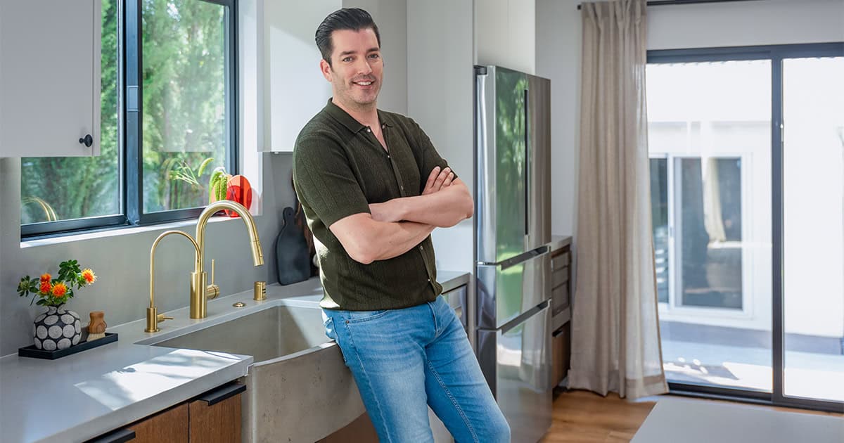 spring cleaning tips and steps from jonathan scott, who is posing in a sparkling clean kitchen