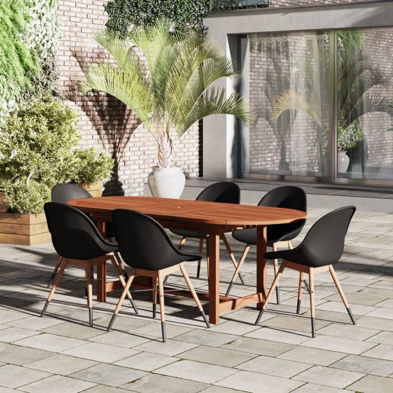 wooden oval outdoor dining table with 6 plastic black chairs