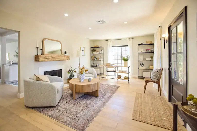 Cozy living room with soft seating, modern shelving, and natural light from the window