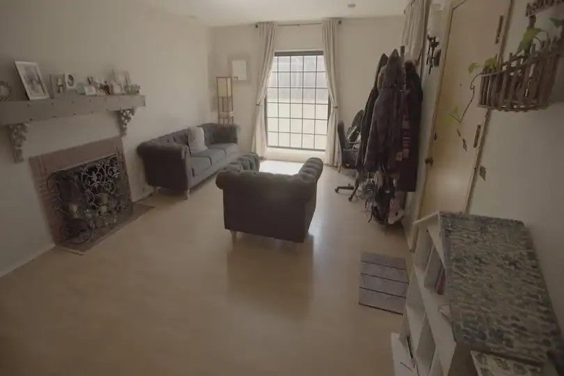Living room with gray sofas, fireplace, and large window