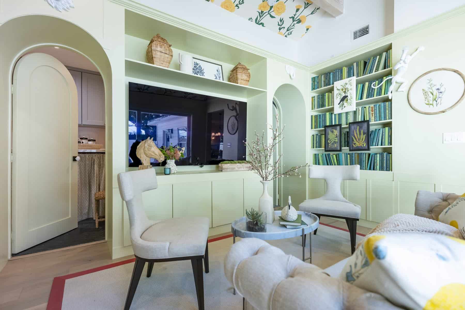 Light green living room with built-ins, botanical accents, and cushioned seating