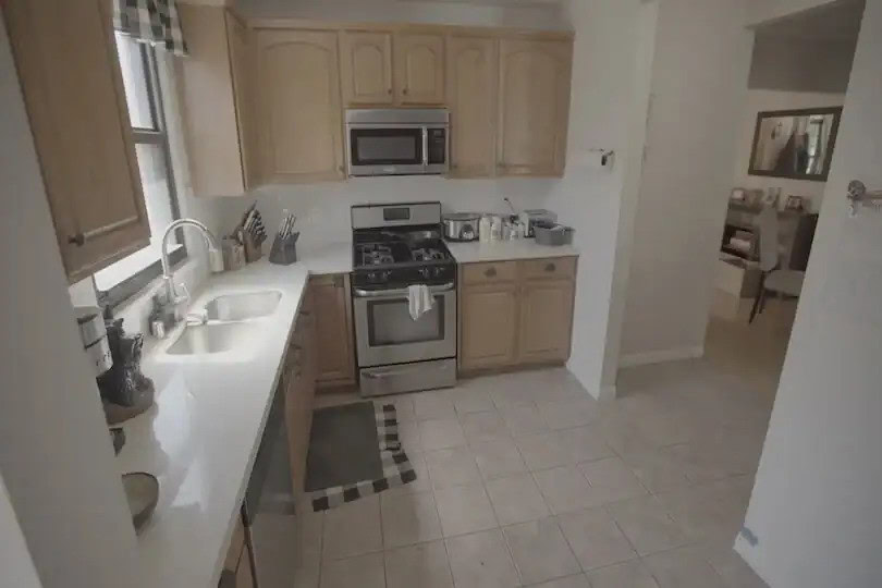 Traditional kitchen with wooden cabinets, stainless steel appliances, and a tiled floor