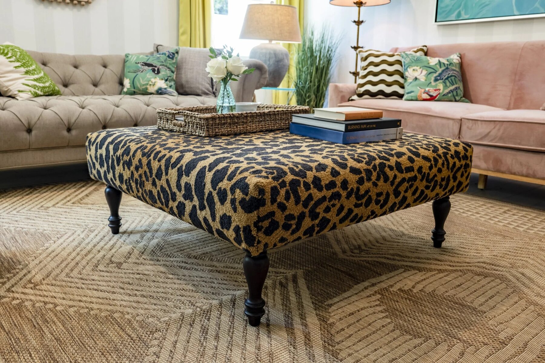 Leopard print ottoman with books and a woven tray