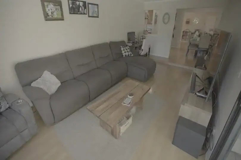 Cozy living room with a large gray sectional sofa, wooden coffee table, and TV setup