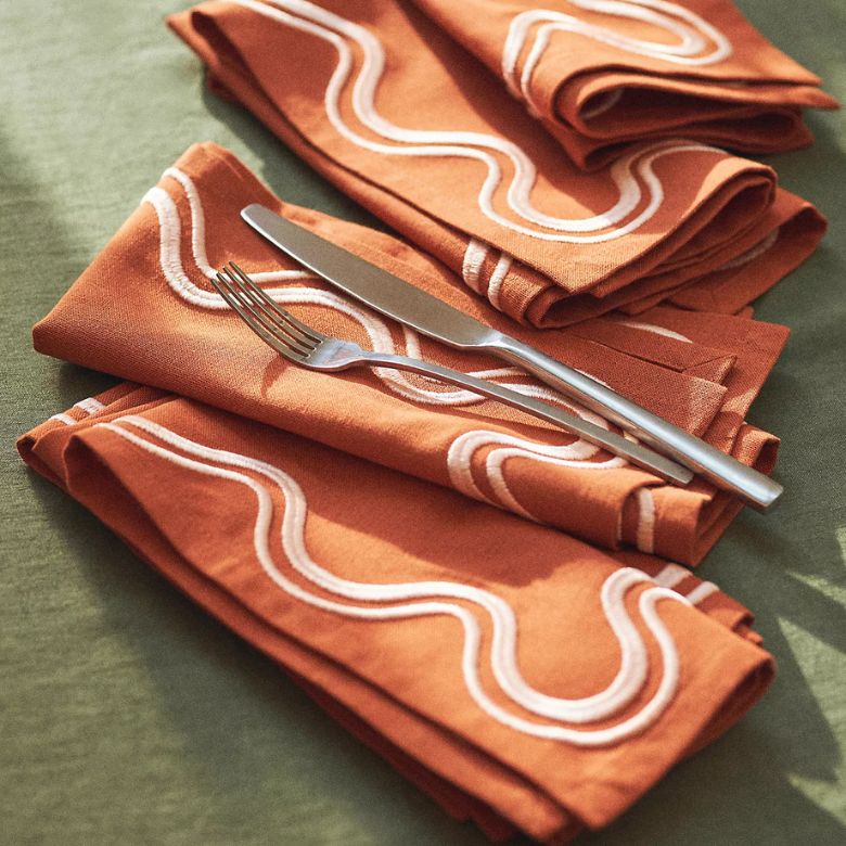orange embroidered napkins with a scallop design