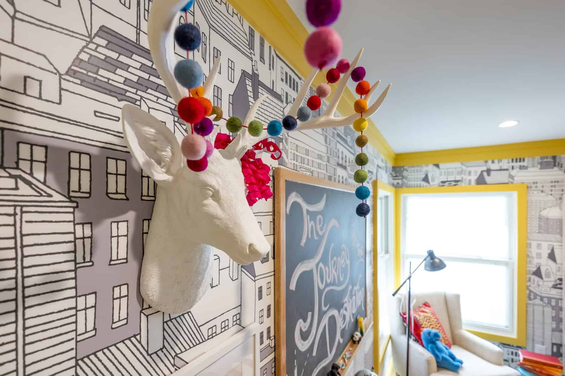 Colorful pom-poms and a playful deer head add charm to this creative space