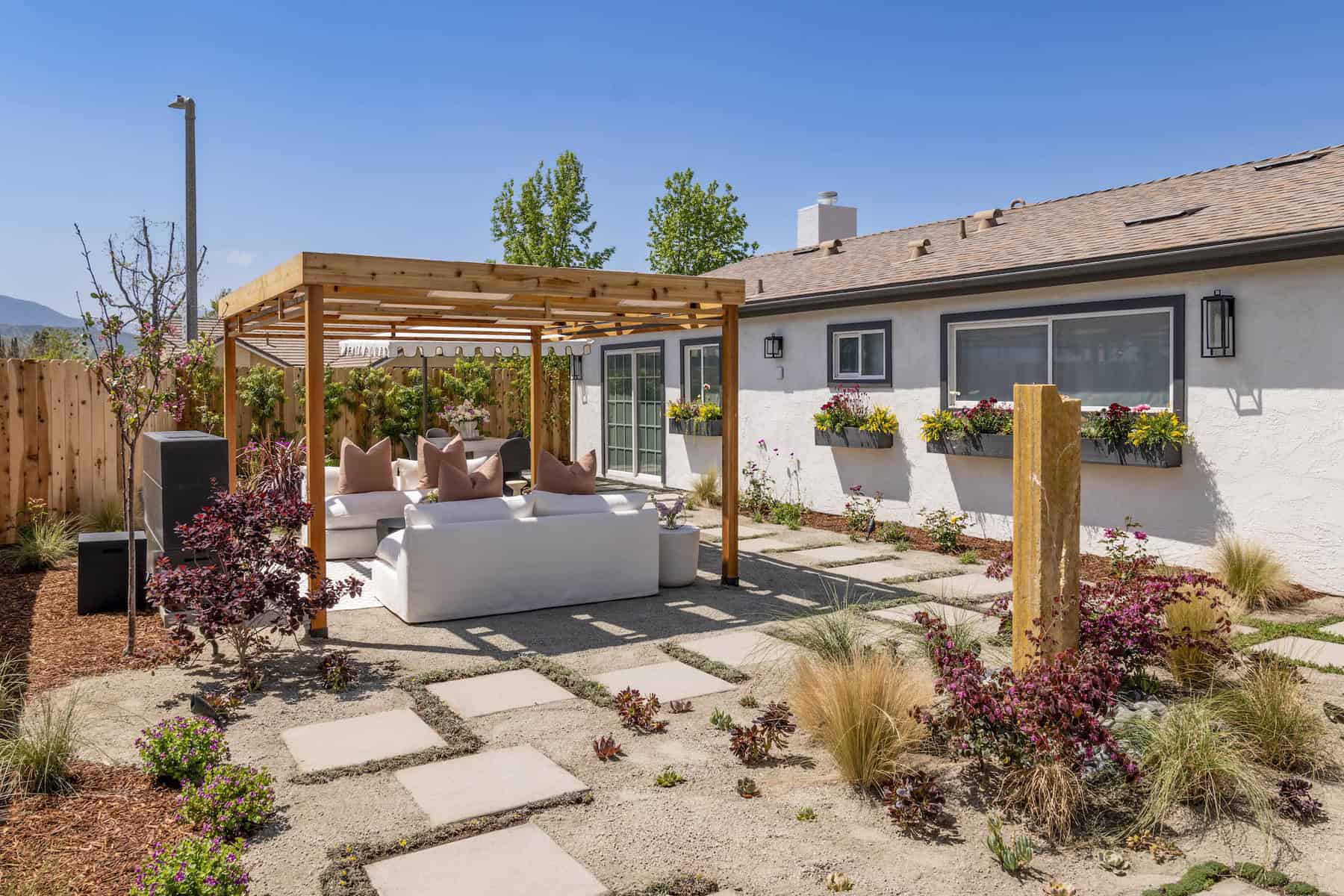White couch under wooden pergola in backyard