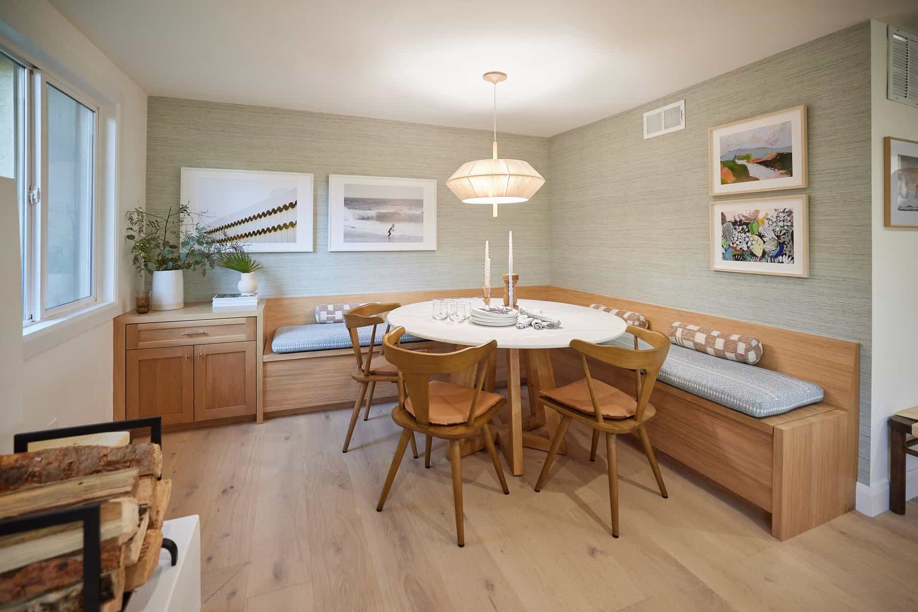 Cozy dining nook with built-in wooden bench seating, round table, and warm modern decor