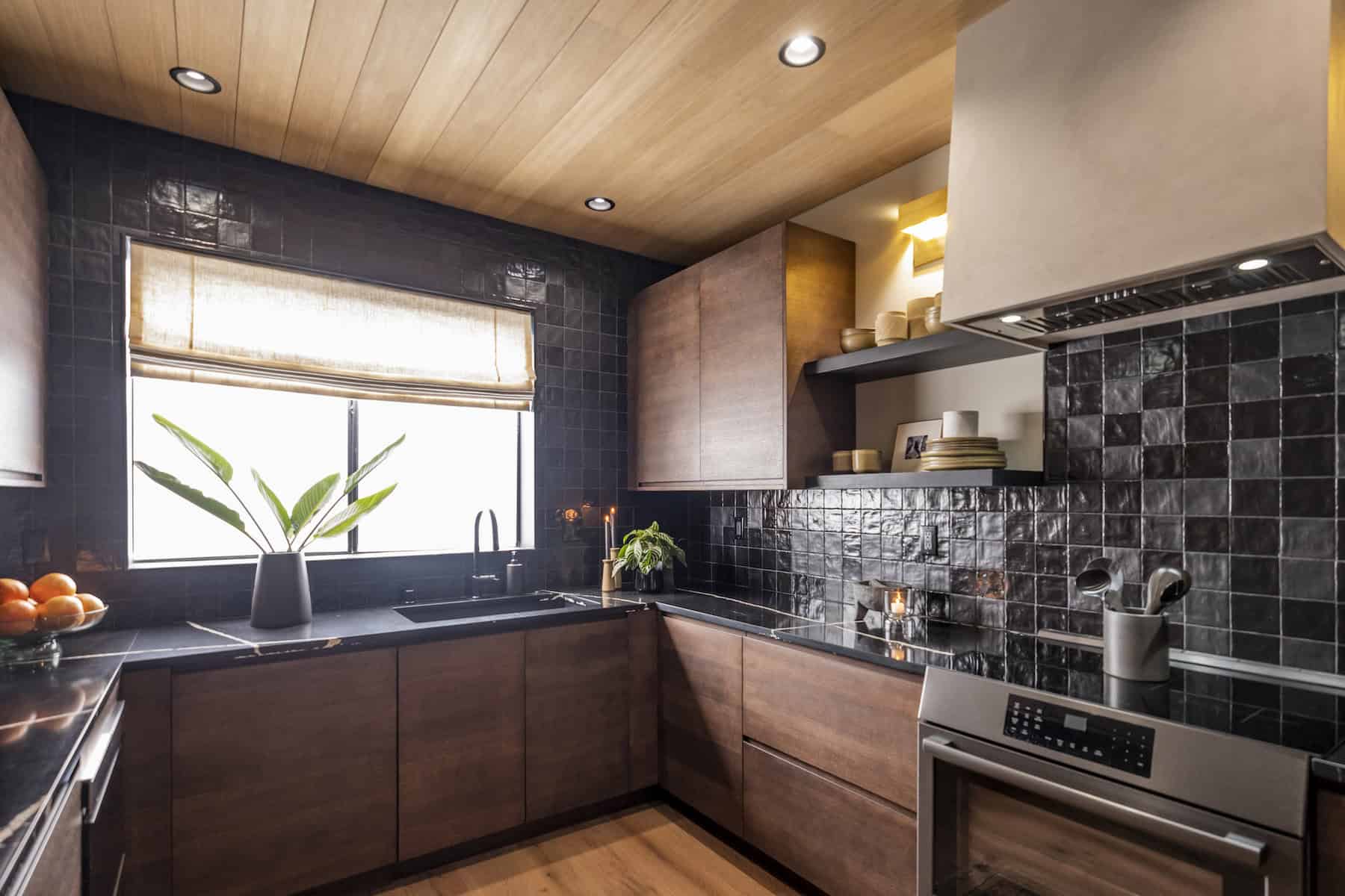 Modern kitchen with black tile backsplash, wood cabinets, and a light wood ceiling