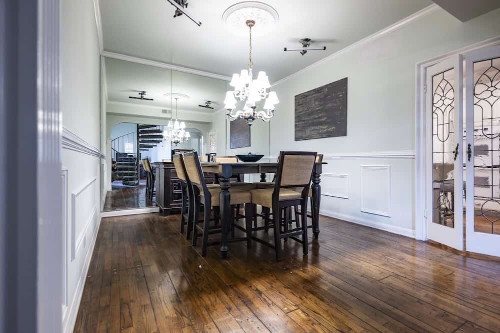 Dining room with wood floors, chandelier, and mirrored wall