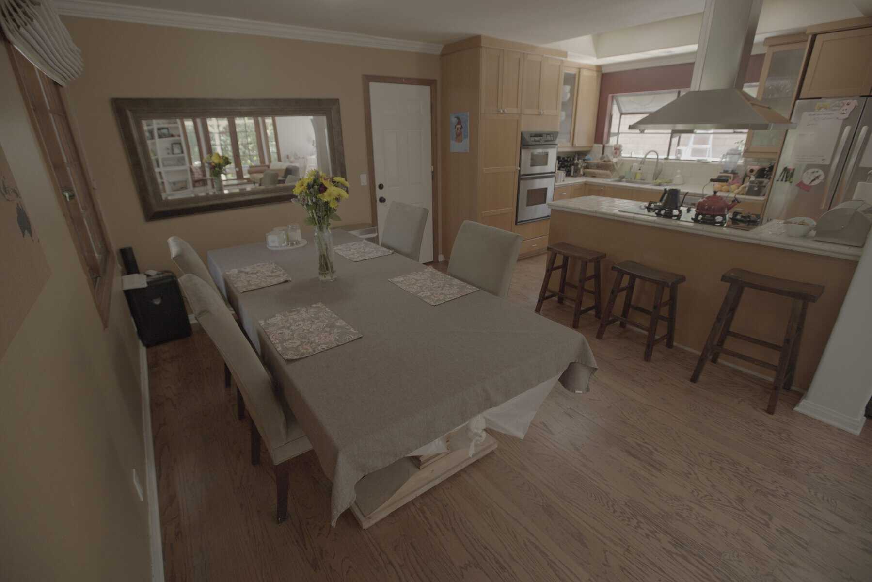 Dining room and kitchen with table and bar stools