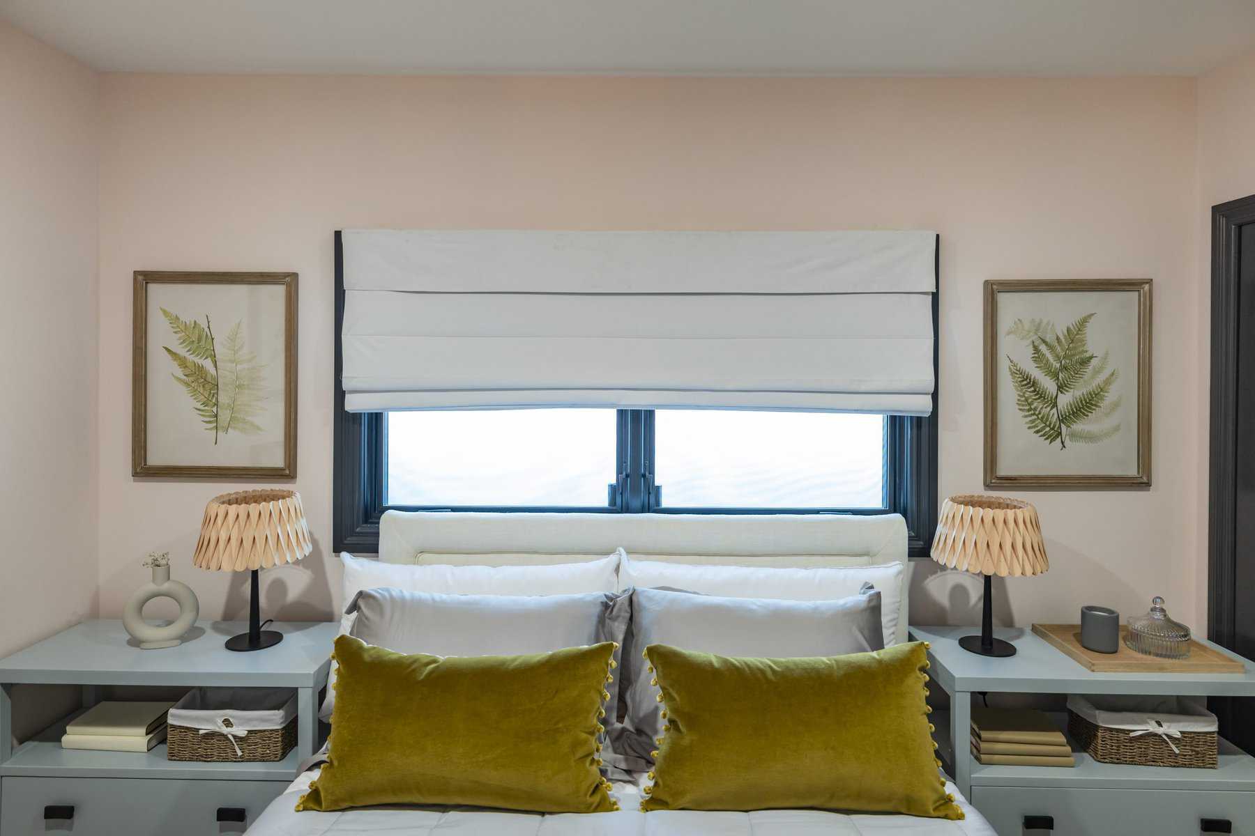 Cozy bedroom with mustard pillows and botanical art