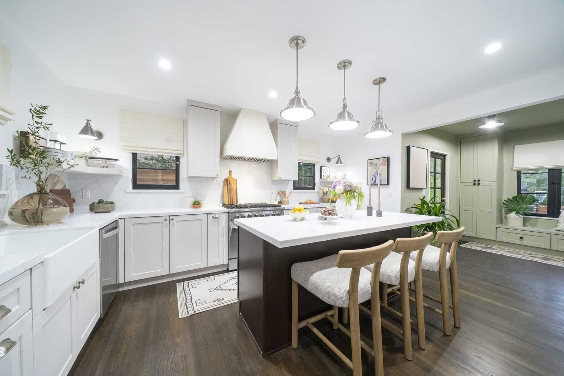 Modern kitchen with marble countertops, gray cabinets, and pendant lighting