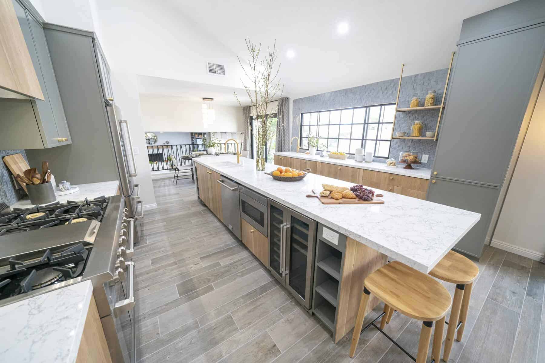 Modern kitchen with marble island, wood accents, and bar stools