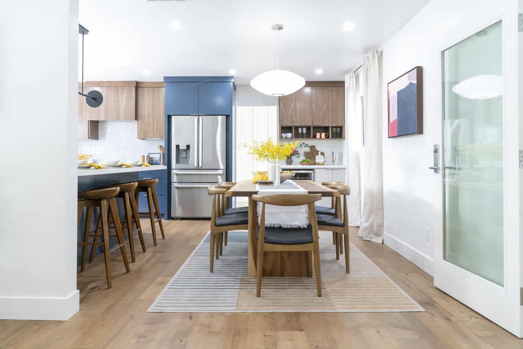 Spacious kitchen and dining room with blue cabinets, a white countertop, and a large dining table