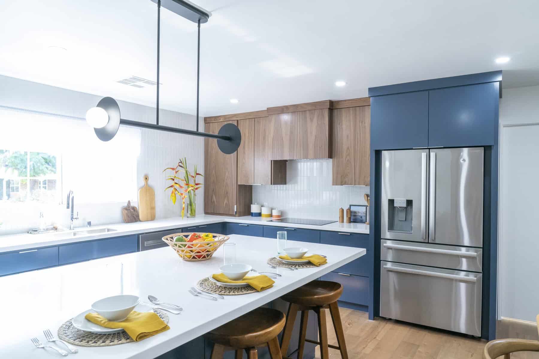 Modern kitchen with wood and navy cabinets, stainless steel appliances, and a large island