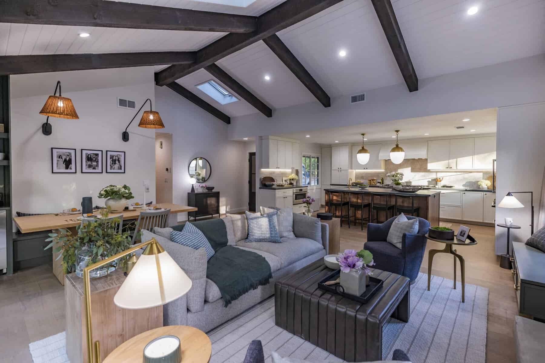 Open-concept living space with exposed beams, cozy seating, and modern kitchen