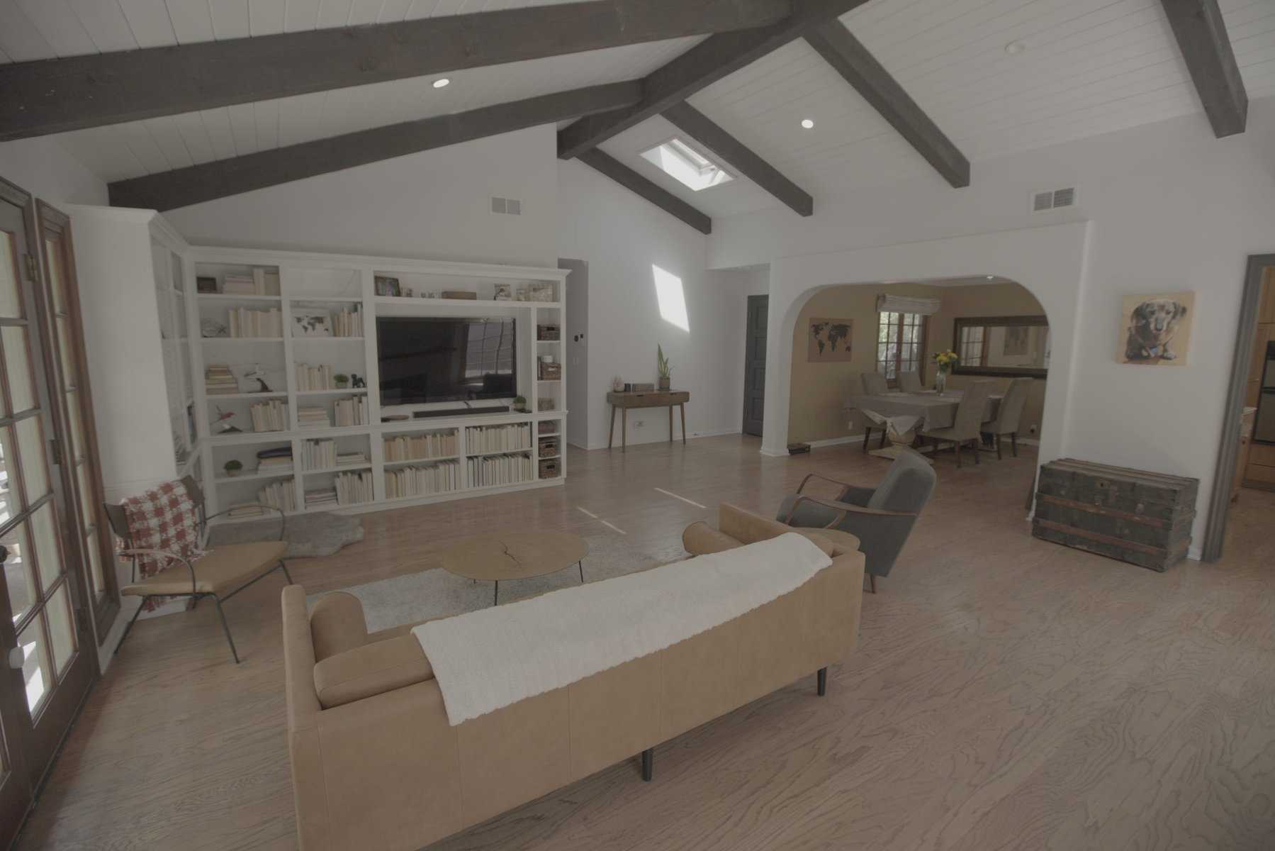 Spacious living room with exposed beams and built in bookshelf