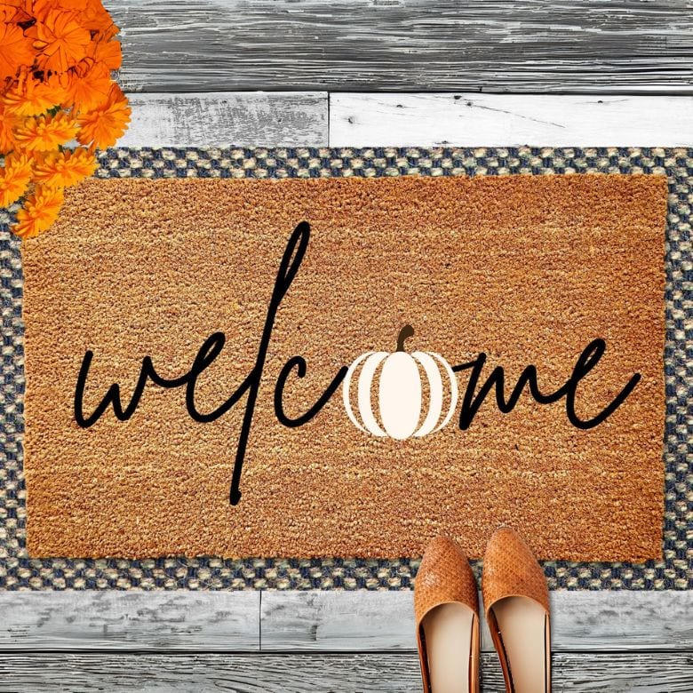 doormat with welcome script and white pumpkin