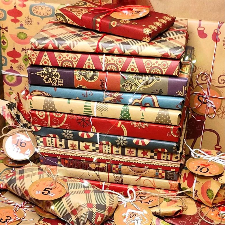 stack of books wrapped in holiday wrapping paper
