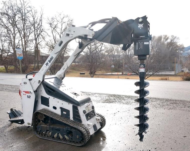 Excavator with auger attachment, ideal for construction and landscaping projects, available for equi.