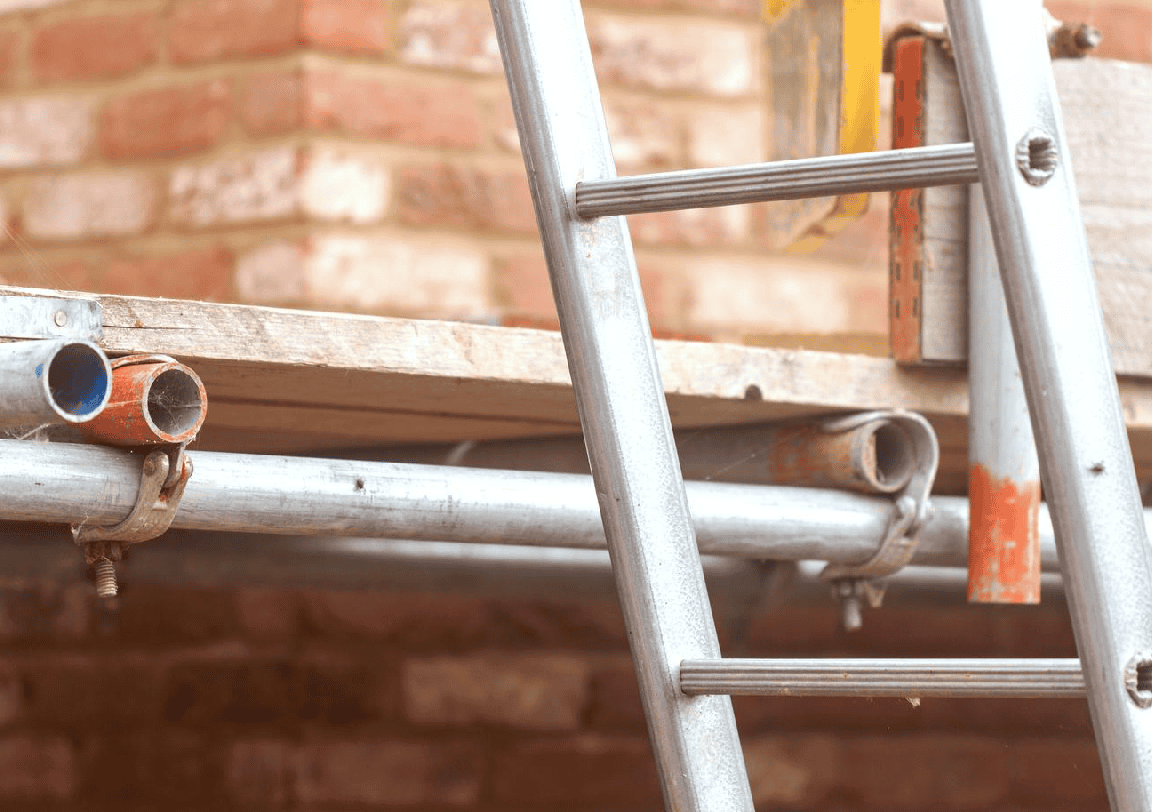 Aluminium scaffold with wooden plank for building maintenance against brick wall.