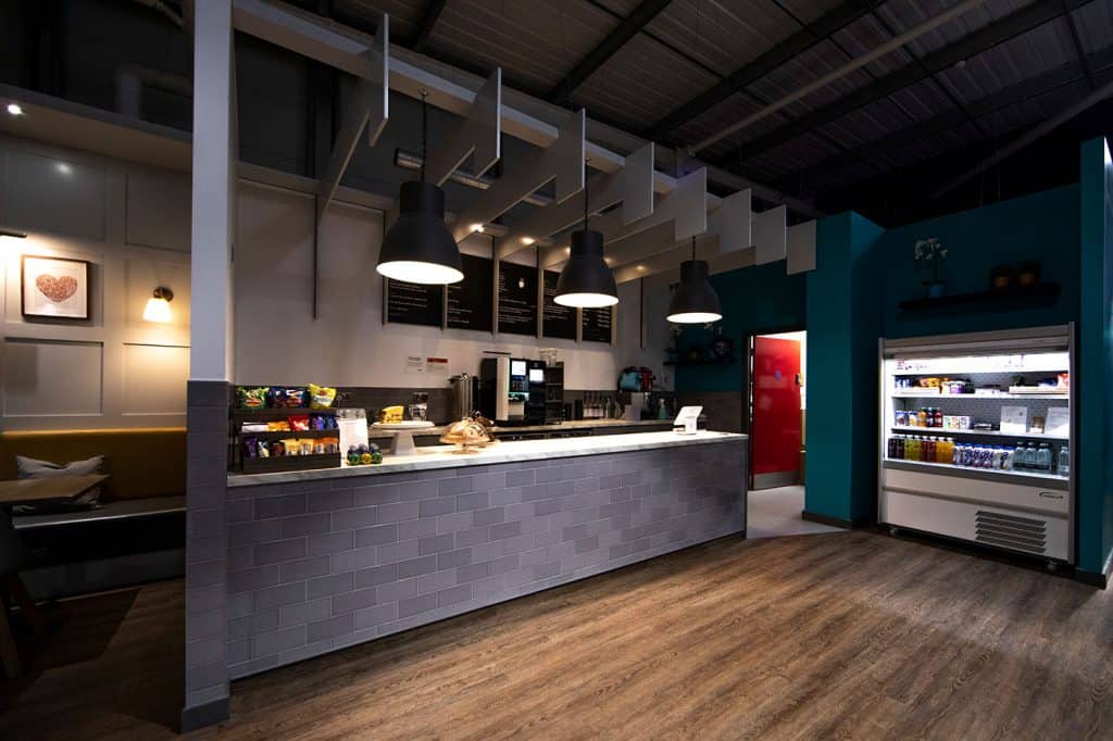 Freshly prepared coffee and snacks station in a modern, cosy cafe with ambient lighting and a colourful, inviting interior.