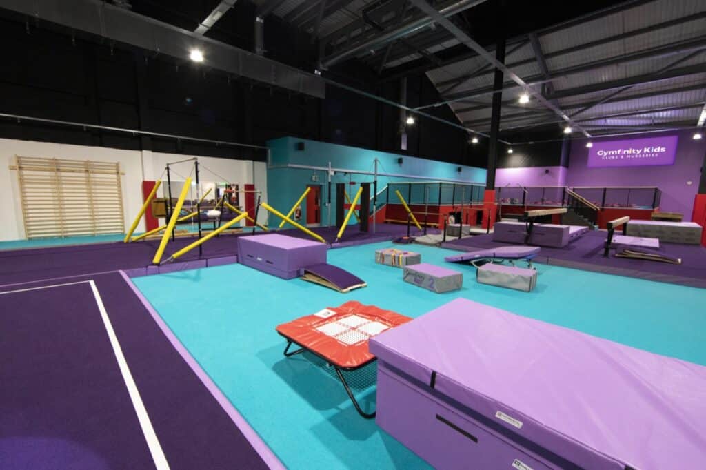 Trampoline park with colourful mats, foam pits, and agility equipment in an indoor sports centre, designed for kids' fitness and fun activities.