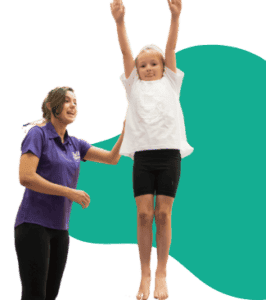 Helping a young girl with a physical disability practice standing and balance during a physiotherapy session. The girl is supported by a therapist to improve her mobility skills.