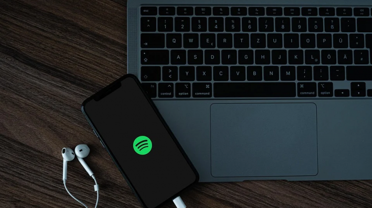 Wireless Spotify streaming on laptop and smartphone for music enthusiasts and digital marketing professionals.