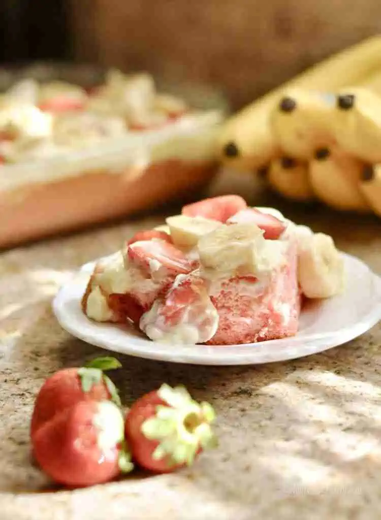 piece of strawberry banana pudding cake on a plate.