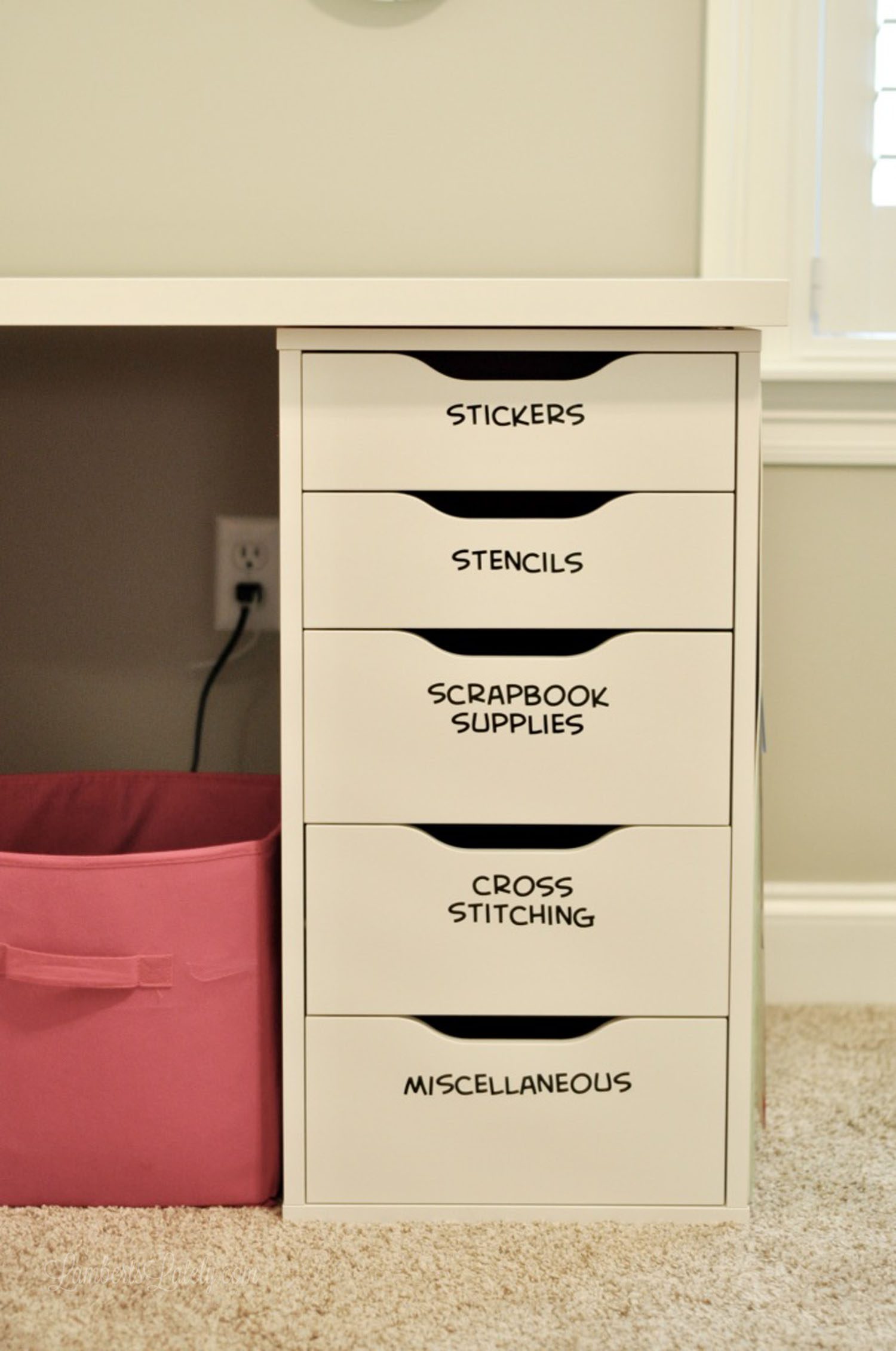 labeled shelves of a desk in a craft room.
