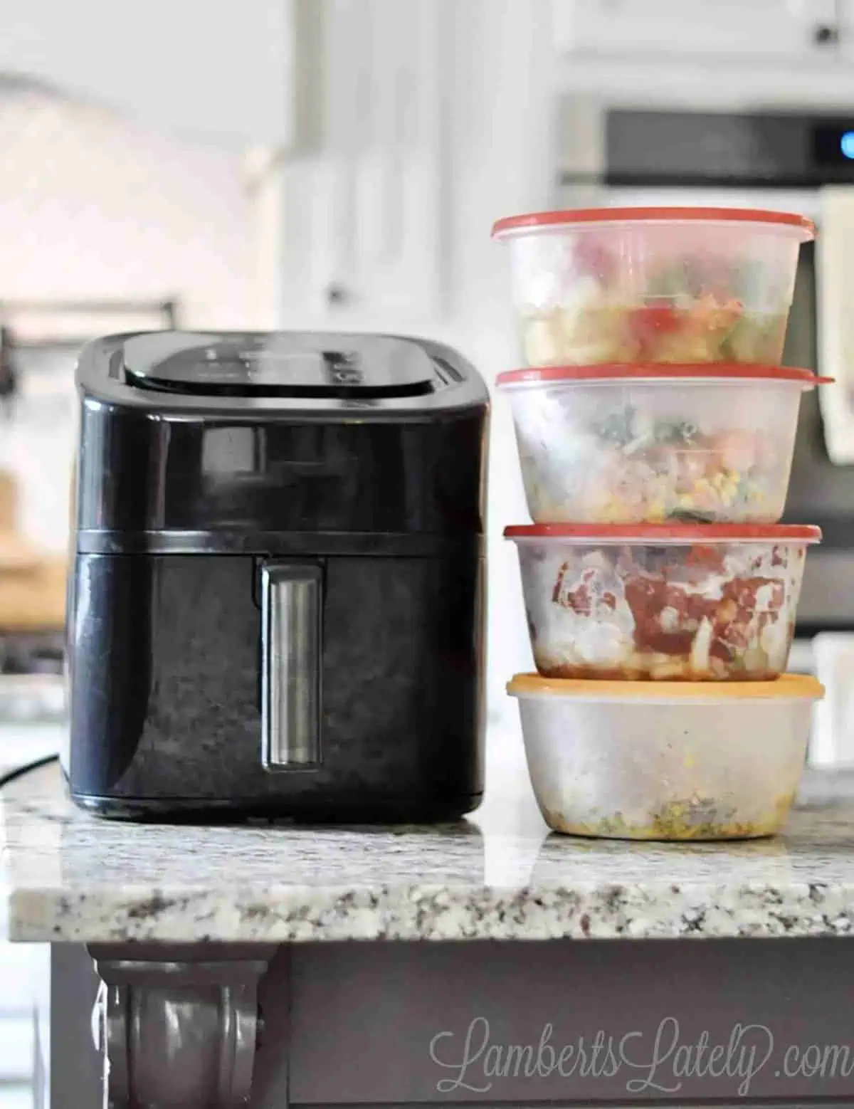 air fryer and several frozen meals in containers on a counter.