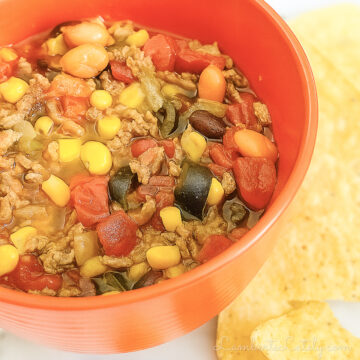 bowl of 7 can taco soup next to tortilla chips.