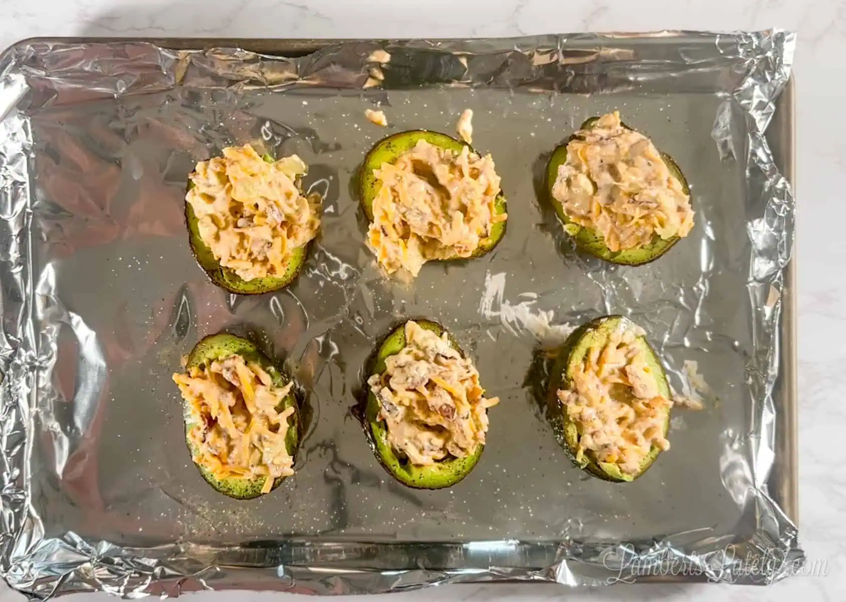 stuffed avocados on a baking sheet.