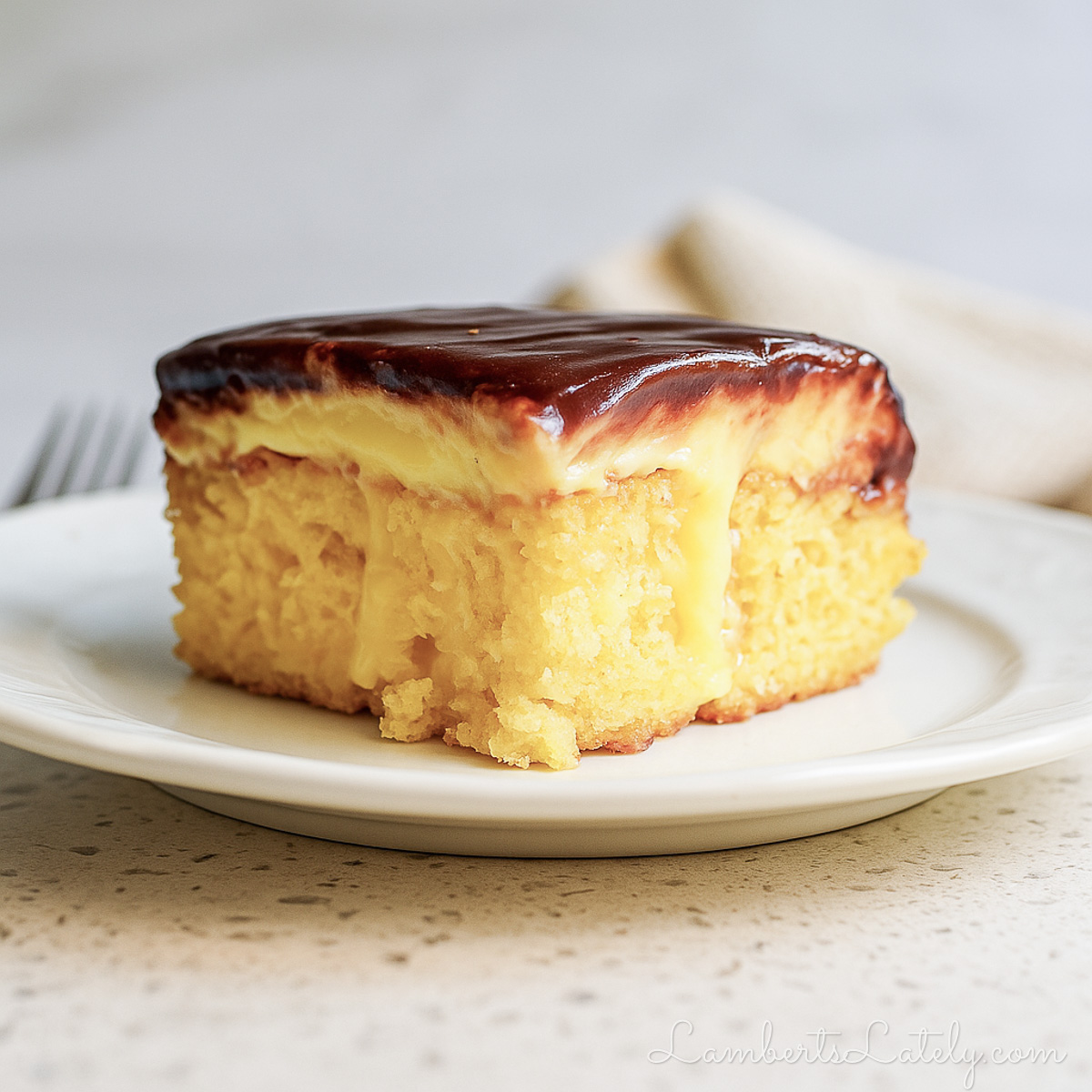 piece of boston cream poke cake on a plate.