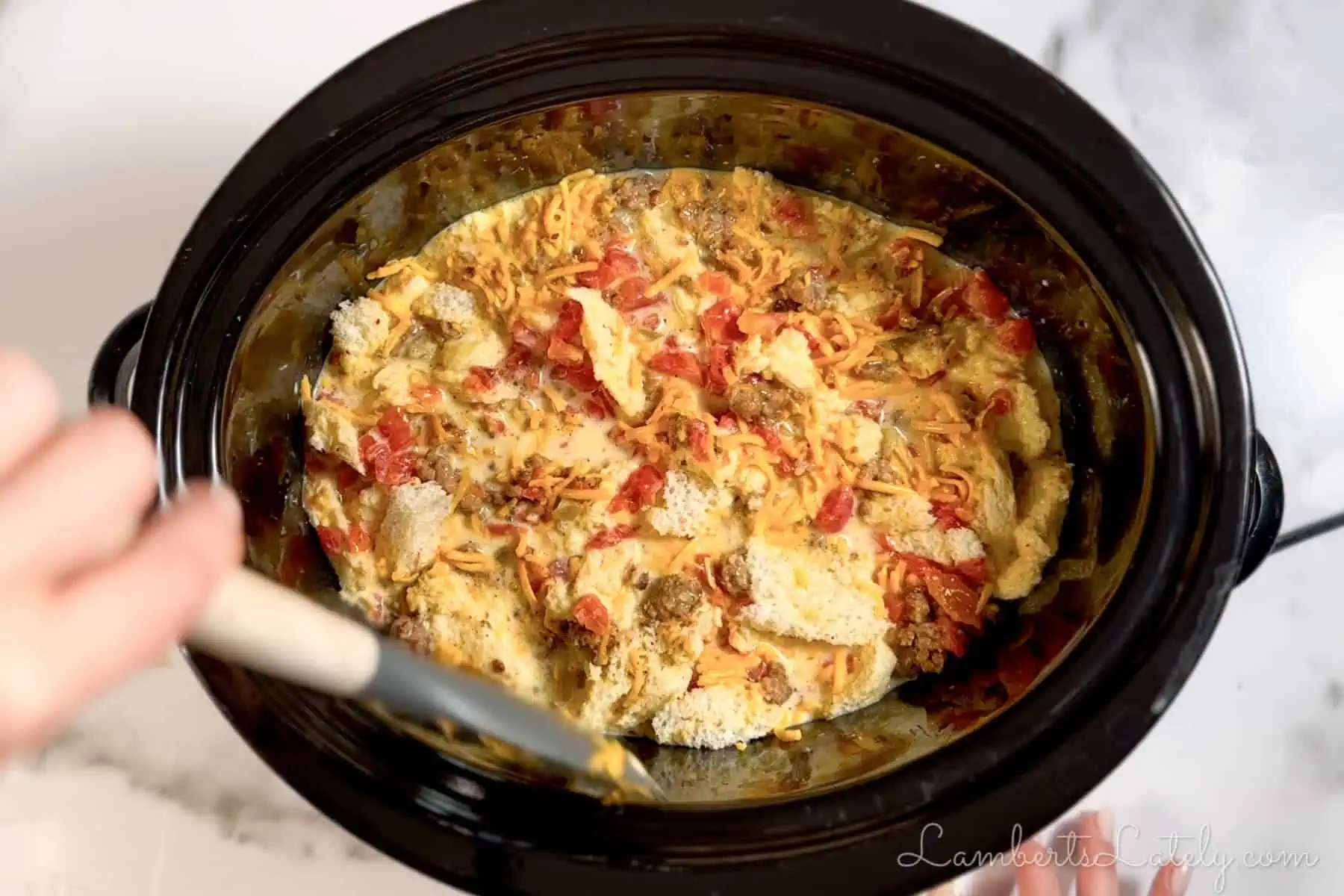 stirring casserole ingredients in a crockpot.