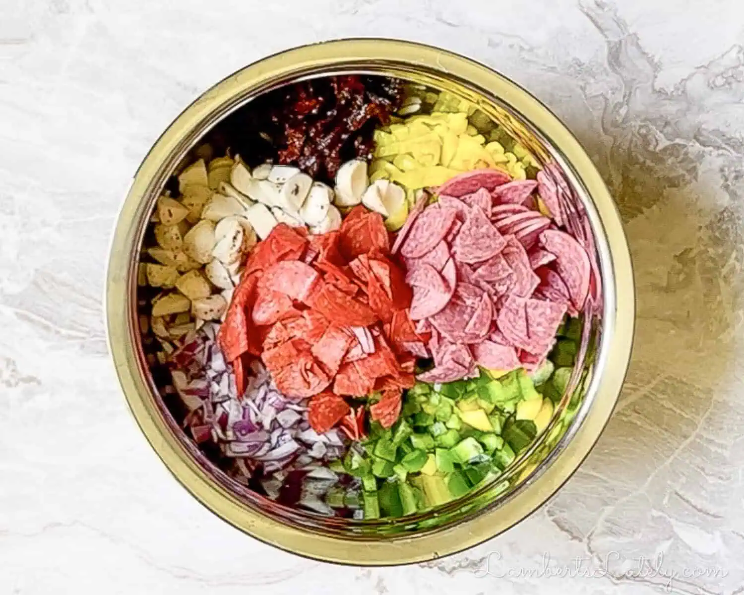 colorful salad elements, unmixed, in a large mixing bowl.