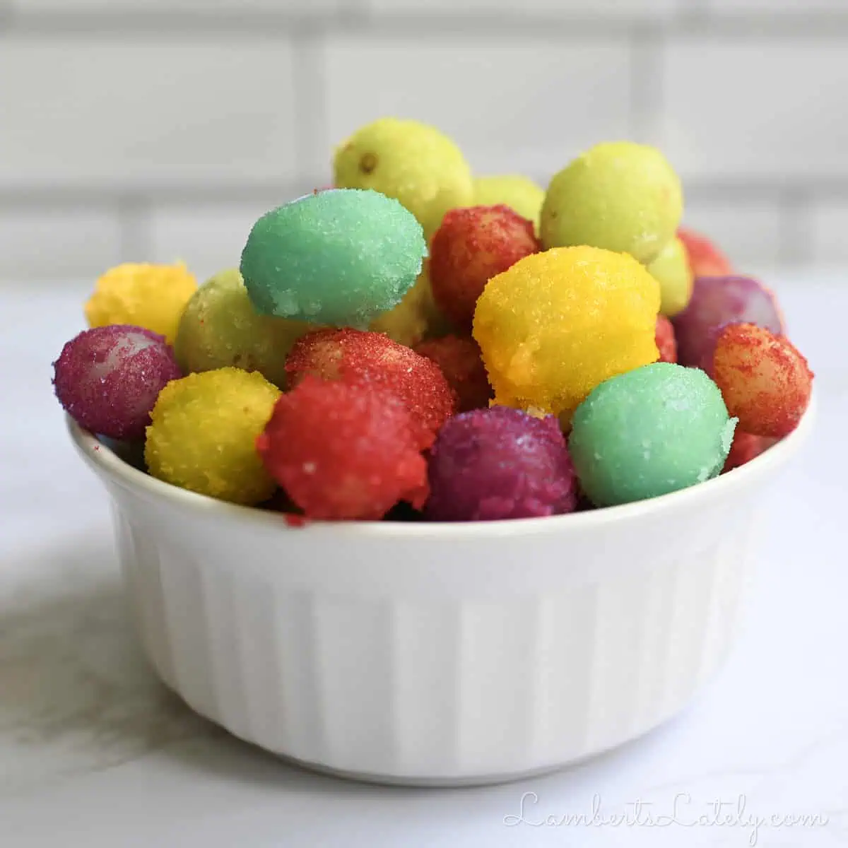sour patch frozen grapes in a ramekin.