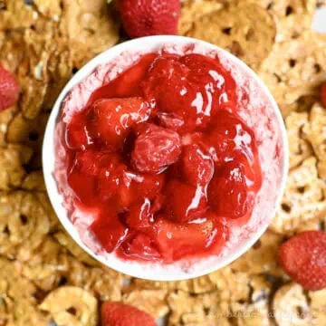 strawberry pretzel dip, topped with strawberry pie filling, surrounded by pretzel chips.