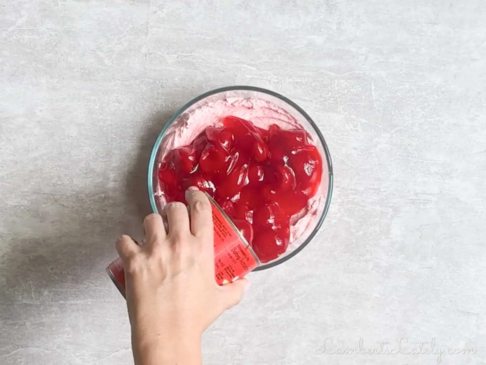 pouring strawberry pie filling over prepared dip.