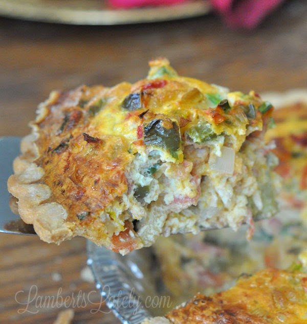 holding a slice of cajun crawfish quiche above the pie.